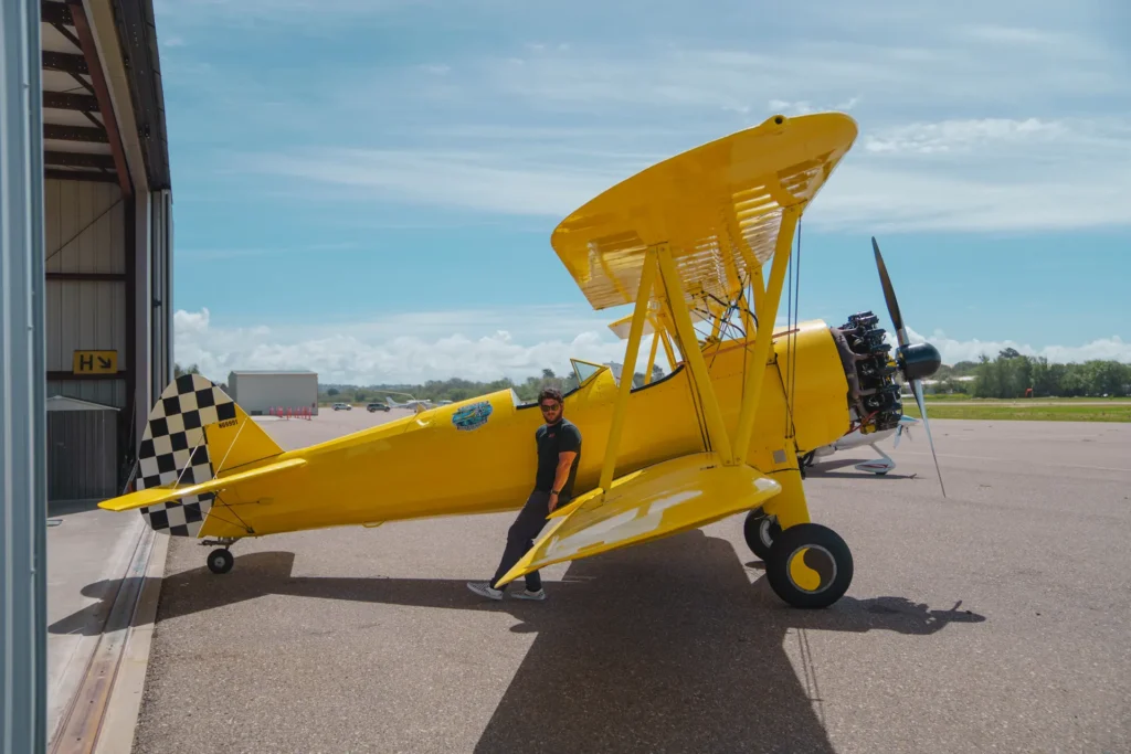 Yellow bi plane with a man leaning on the wing on the ramp at Oceano Airport